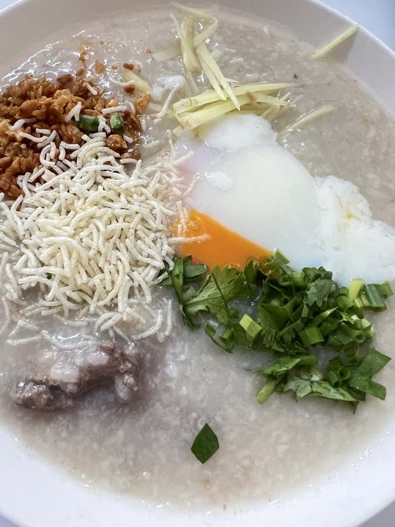 โจ๊กใส่ไข่ลวก ขิงซอย ต้นหอม และของทอดกรอบ